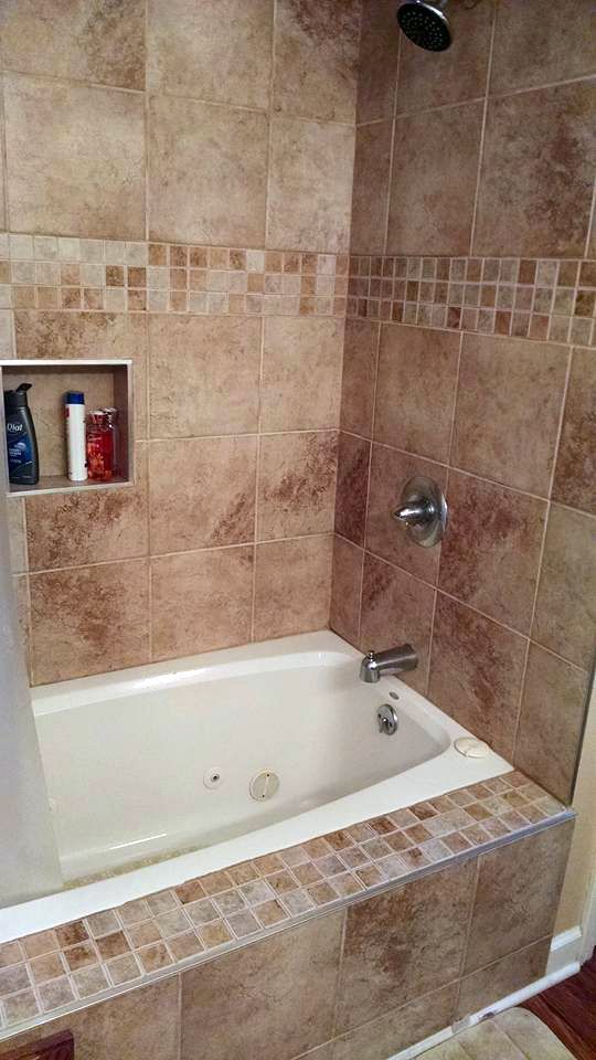 A bathtub in a bathroom next to a shower.