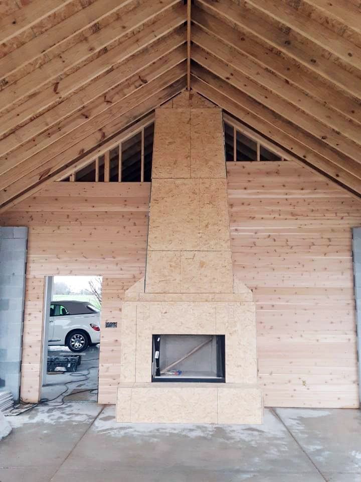 A large wooden fireplace in a building under construction