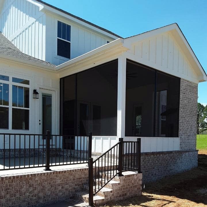 A white house with a screened in porch and stairs