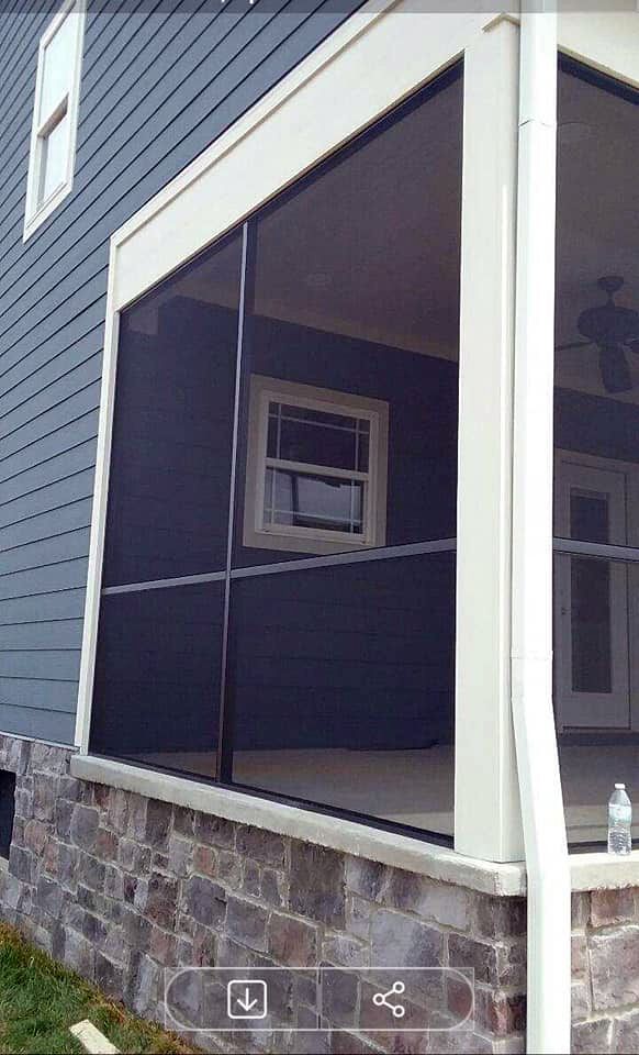 A screened in porch on the side of a house