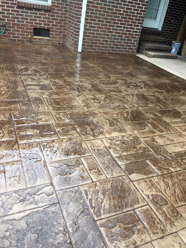 A concrete patio with a brick wall in the background.