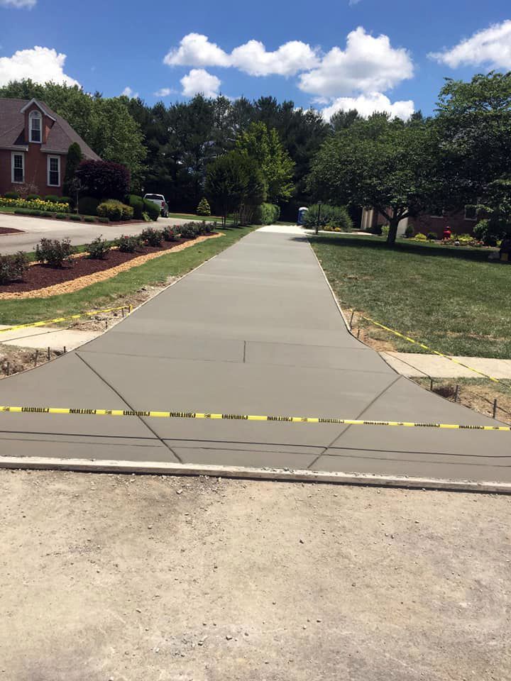 A concrete driveway is being built in front of a house