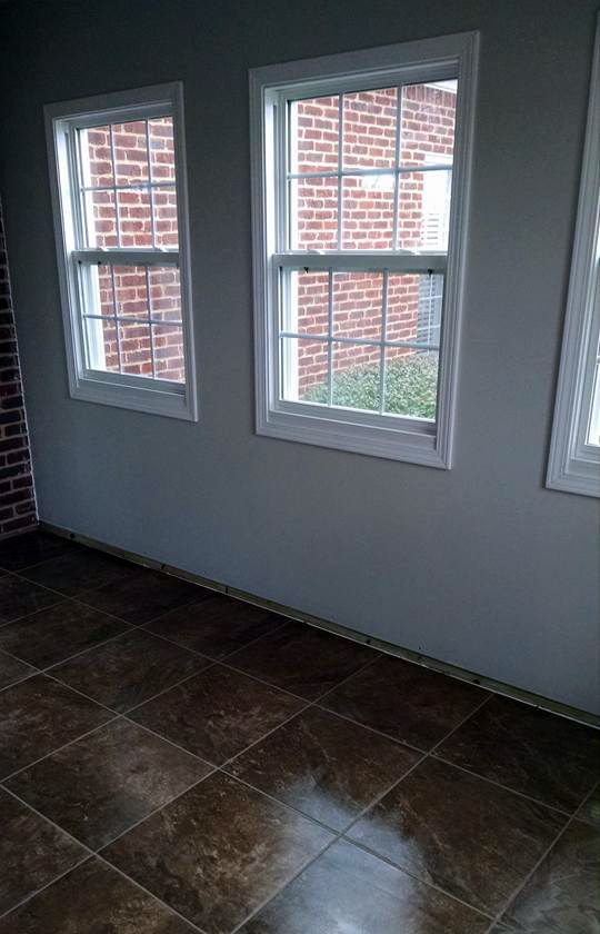 A room with three windows and a tiled floor.