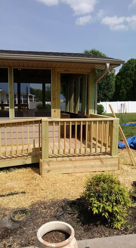 A wooden deck is being built in front of a house.