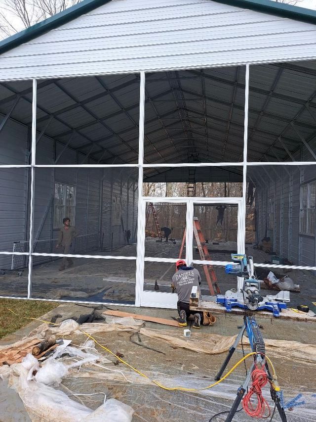 A screened in porch is being built in the backyard of a house.