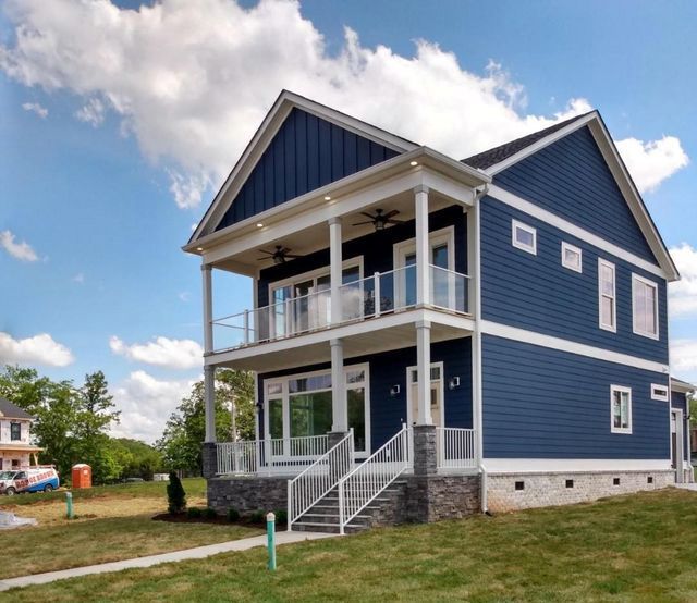 A large blue house with a porch and stairs