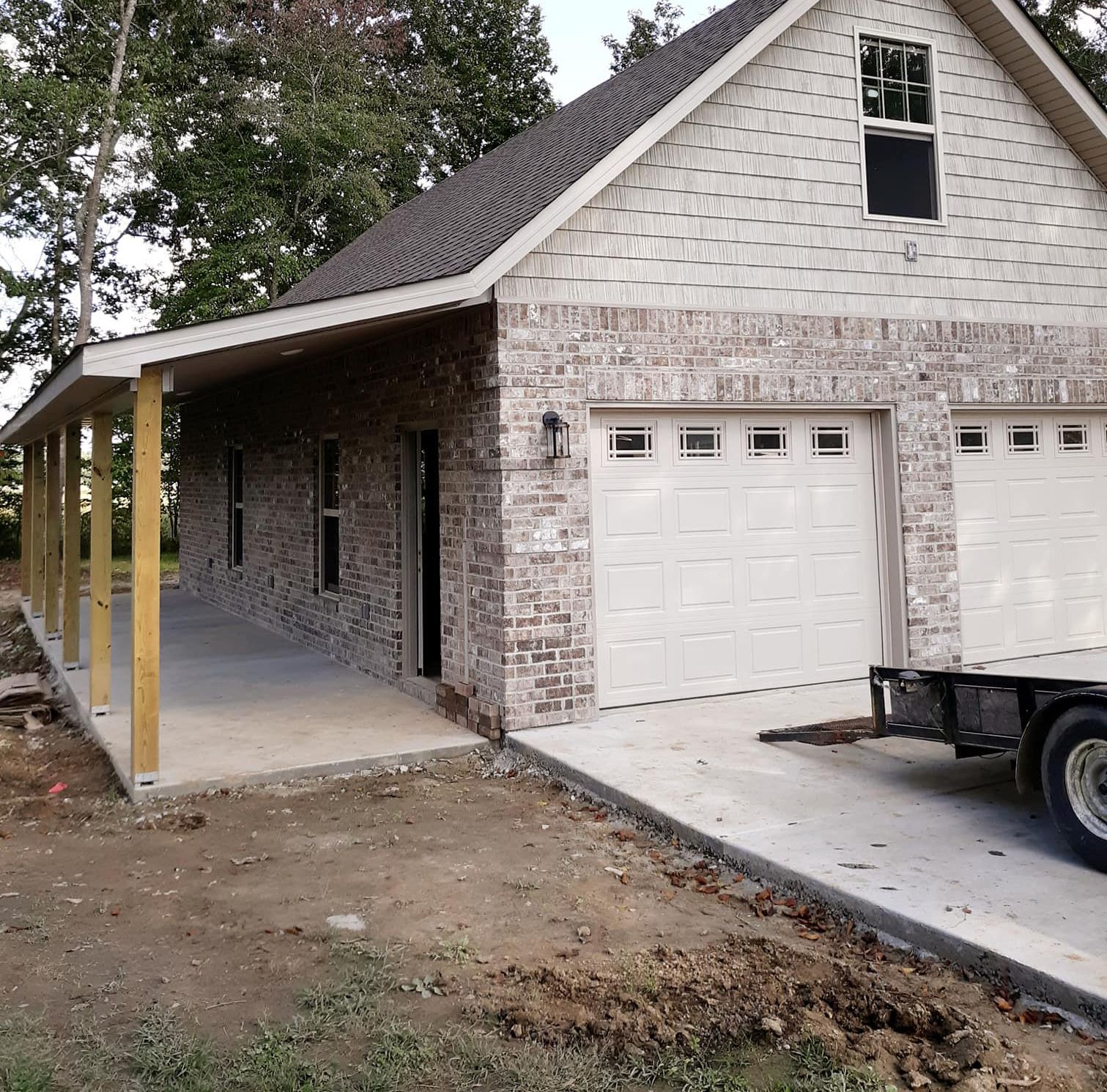 A tow truck is parked in front of a brick house