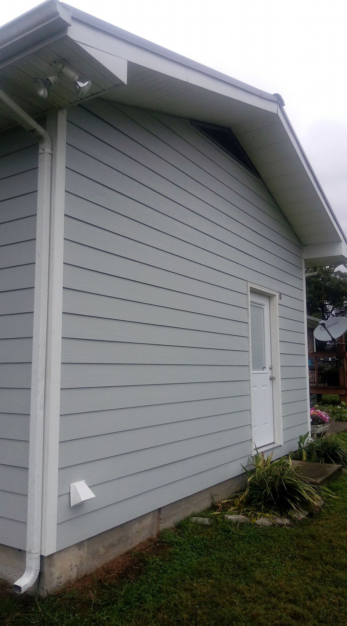 A small house with a white siding and a white door.