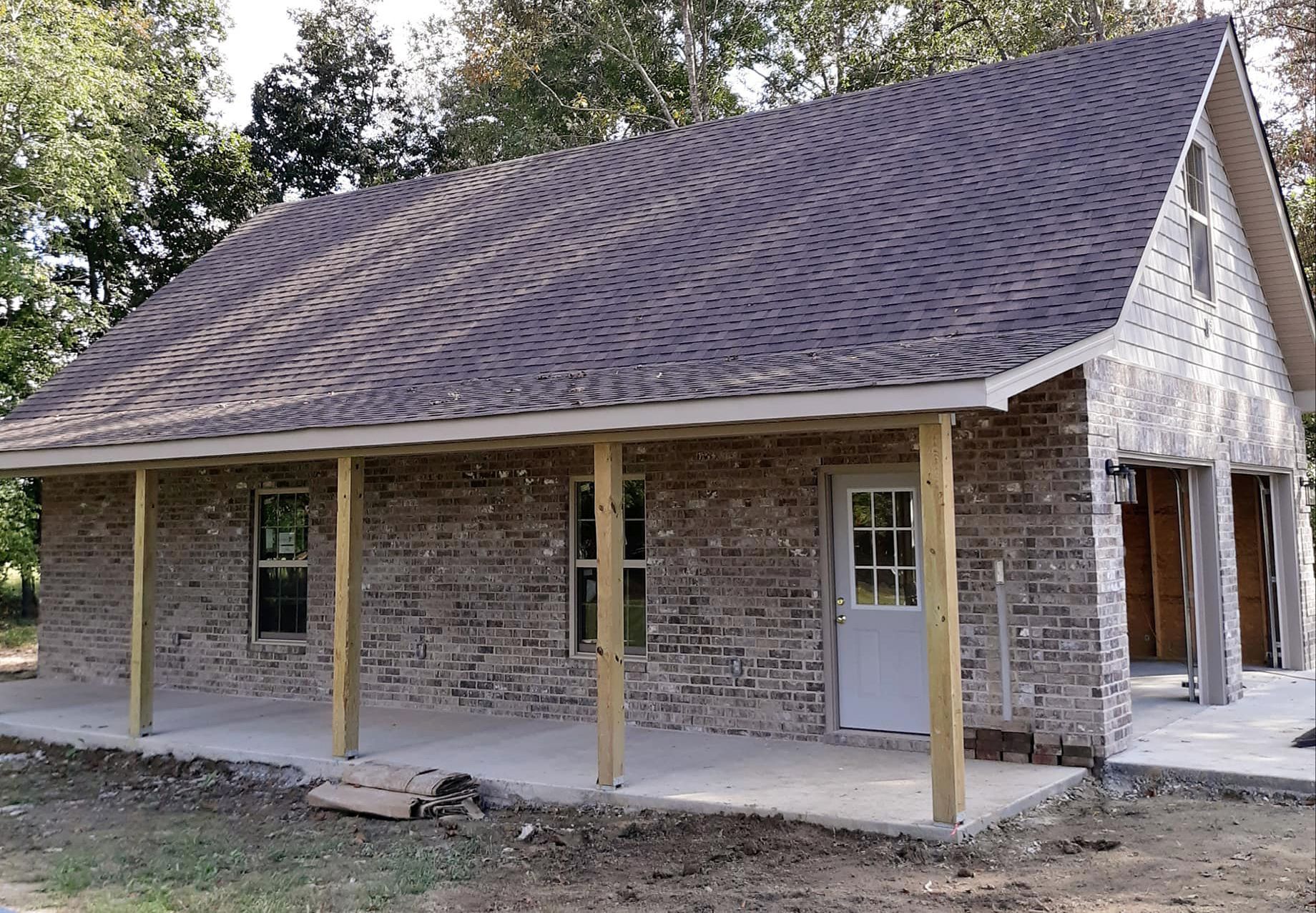 A brick house with a porch and a roof