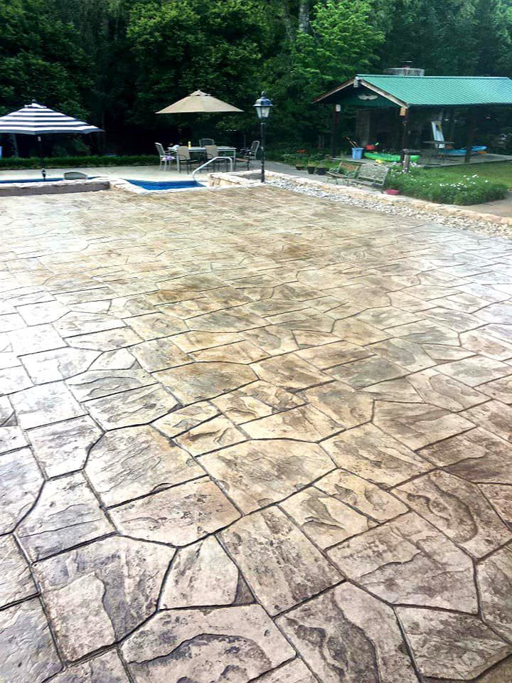 A patio with umbrellas and a pool in the background.