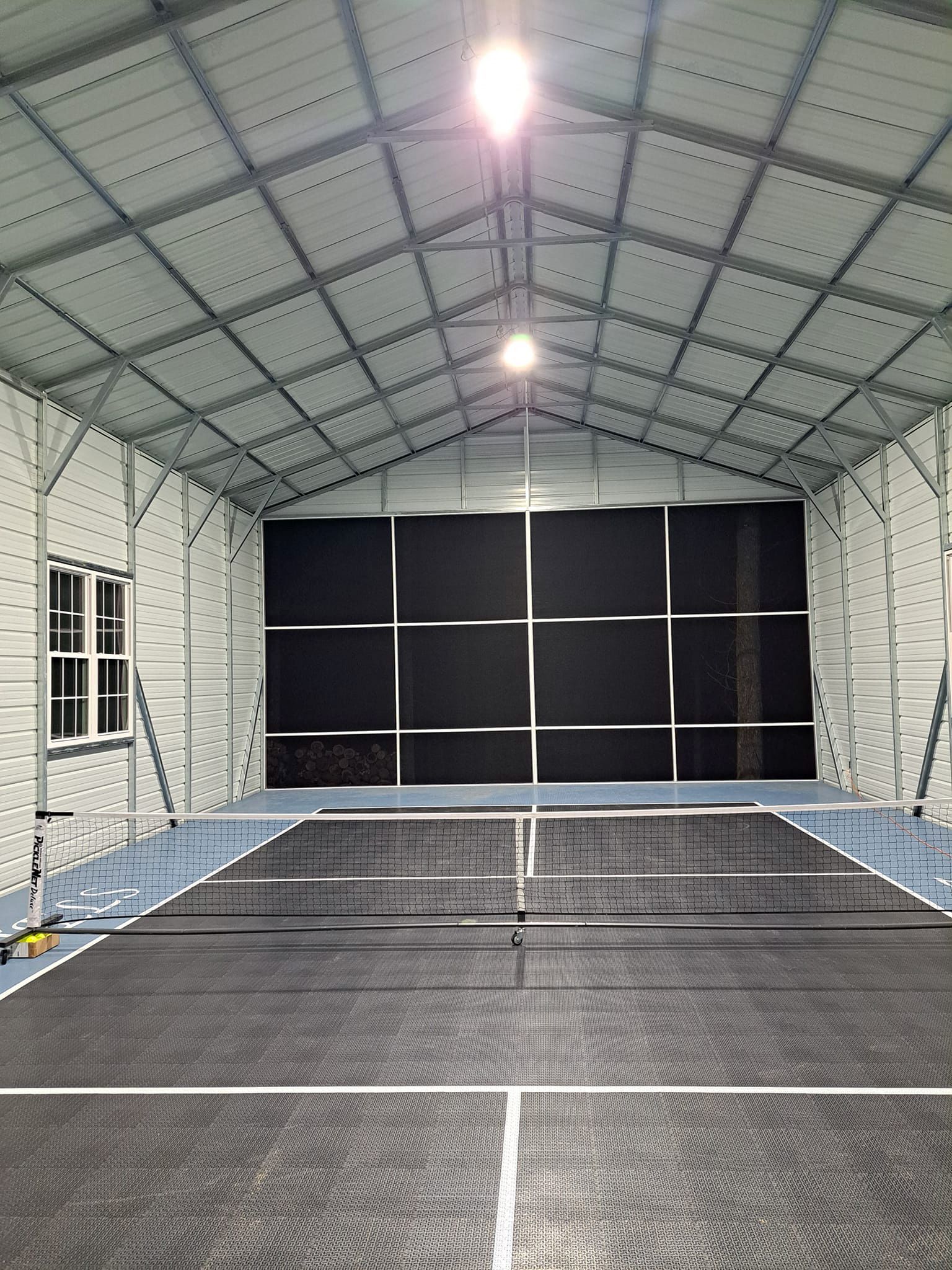 There is a tennis court inside of a building.