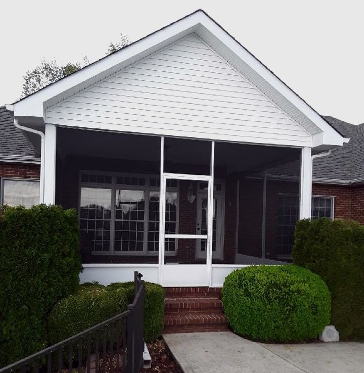 A house with a screened in porch and stairs