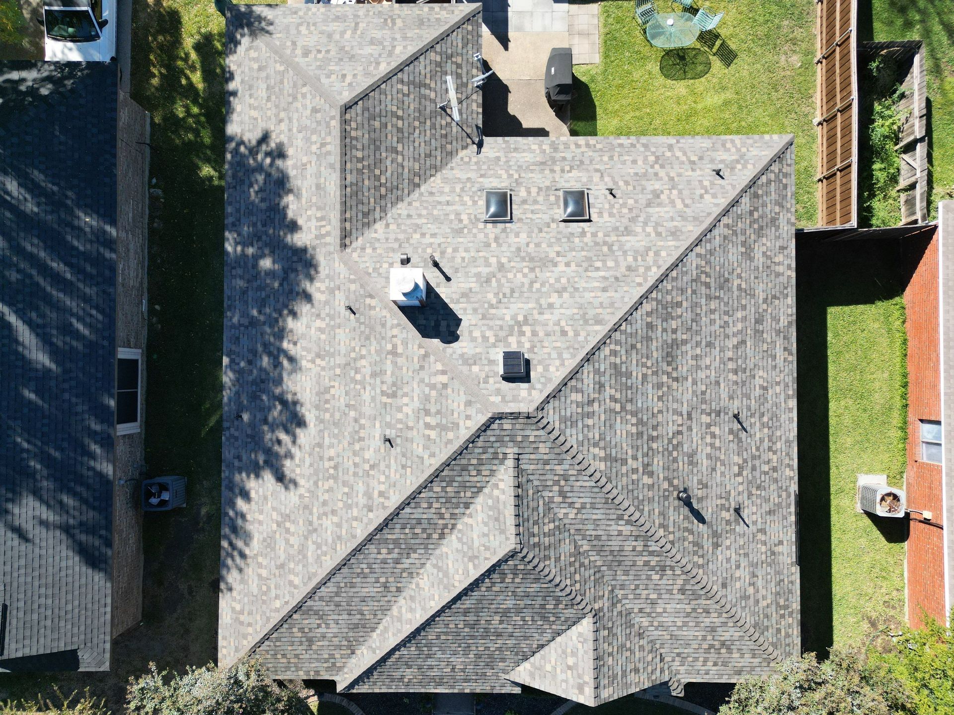 An aerial view of a house with a roof that has a lot of windows.