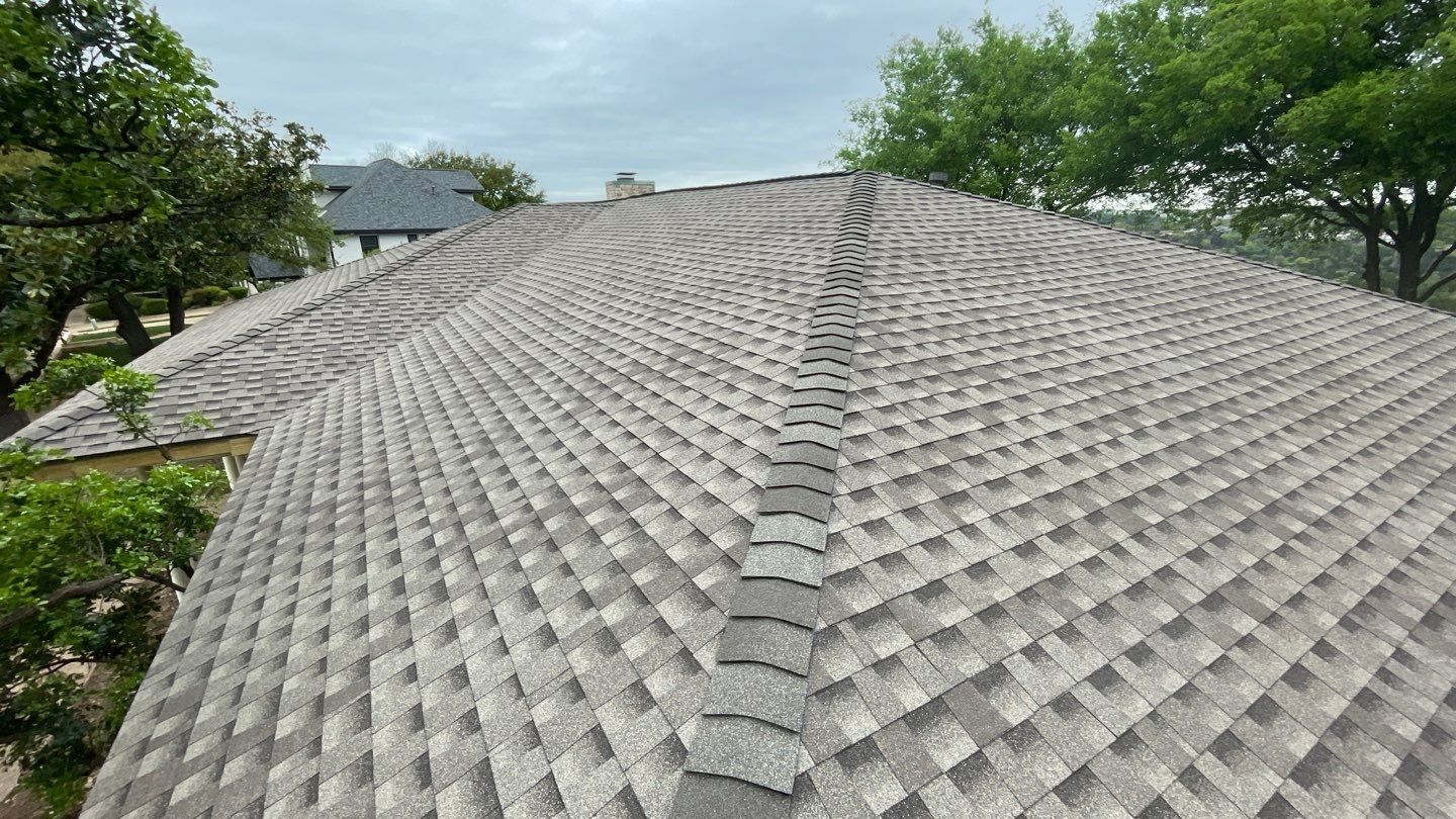 A close up of a roof with trees in the background.