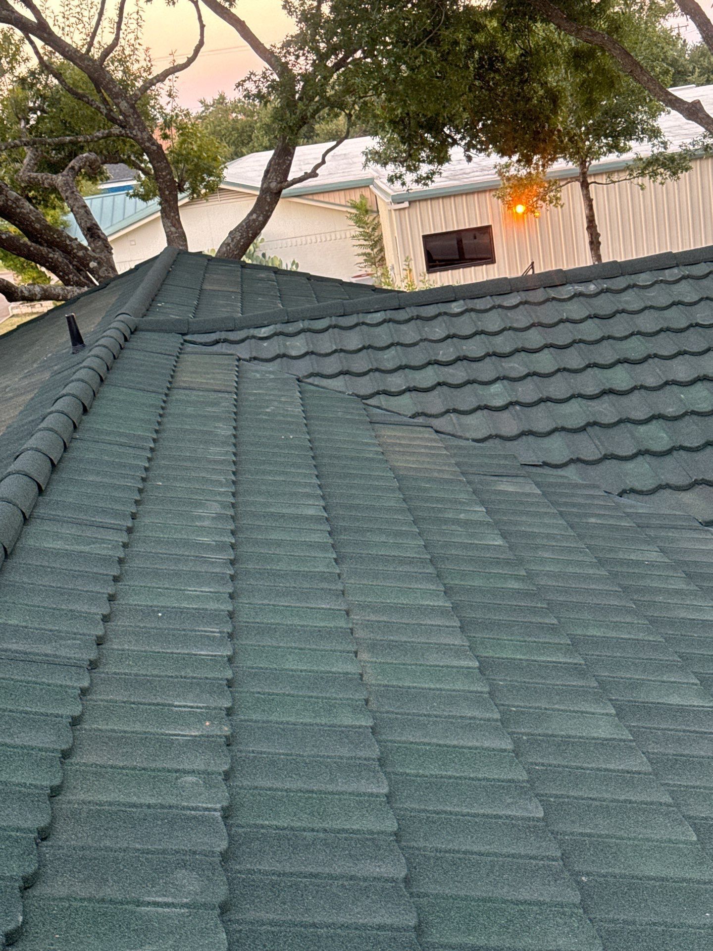 A close up of a tiled roof with trees in the background.