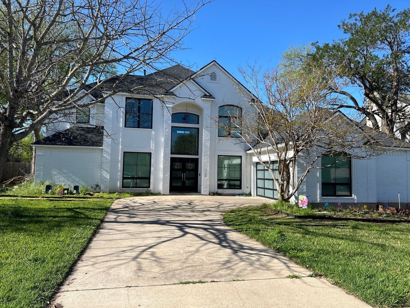 A large white house with a driveway leading to it.