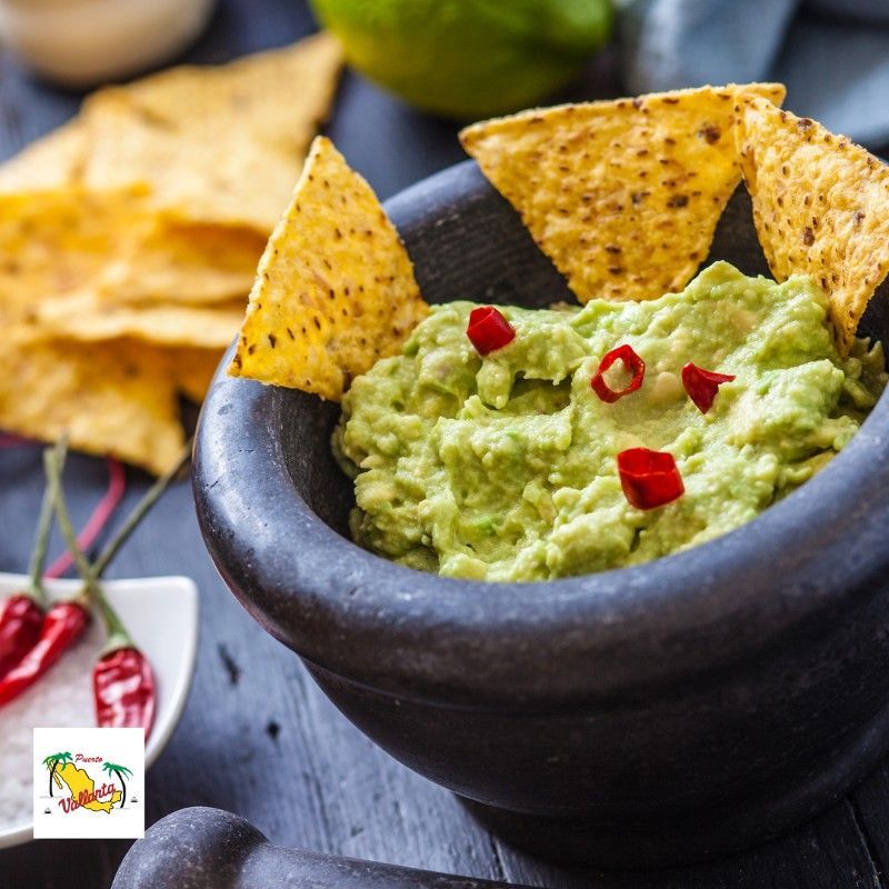 A bowl of guacamole with tortilla chips on top