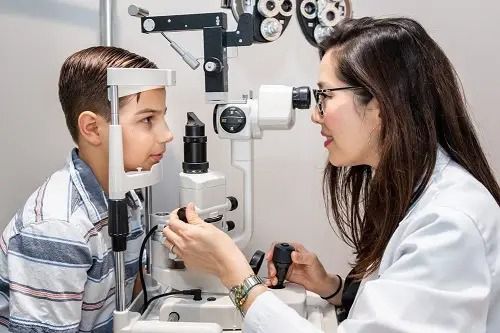 A professional eye exam where an optometrist uses a slit-lamp microscope to examine a patient's eyes.