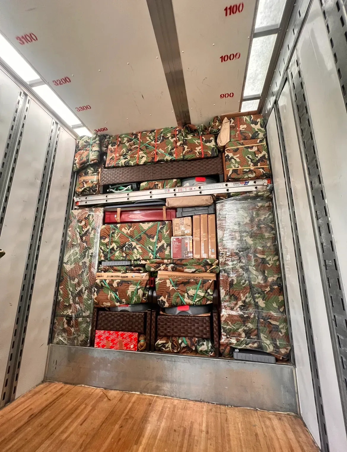 Cargo truck interior packed with colorful boxes and wrapped goods stacked to the ceiling