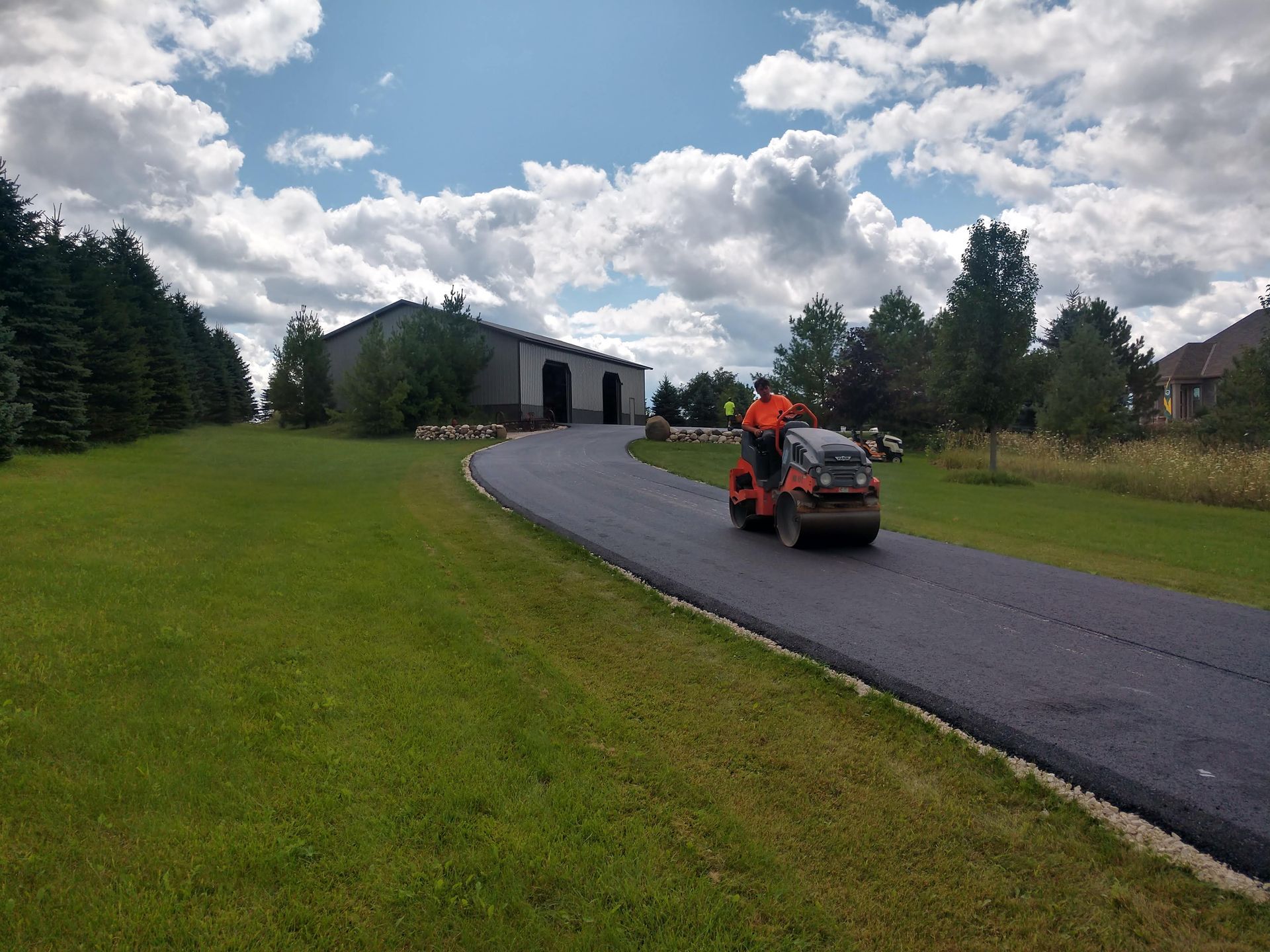 A man is riding a lawn mower down a road.