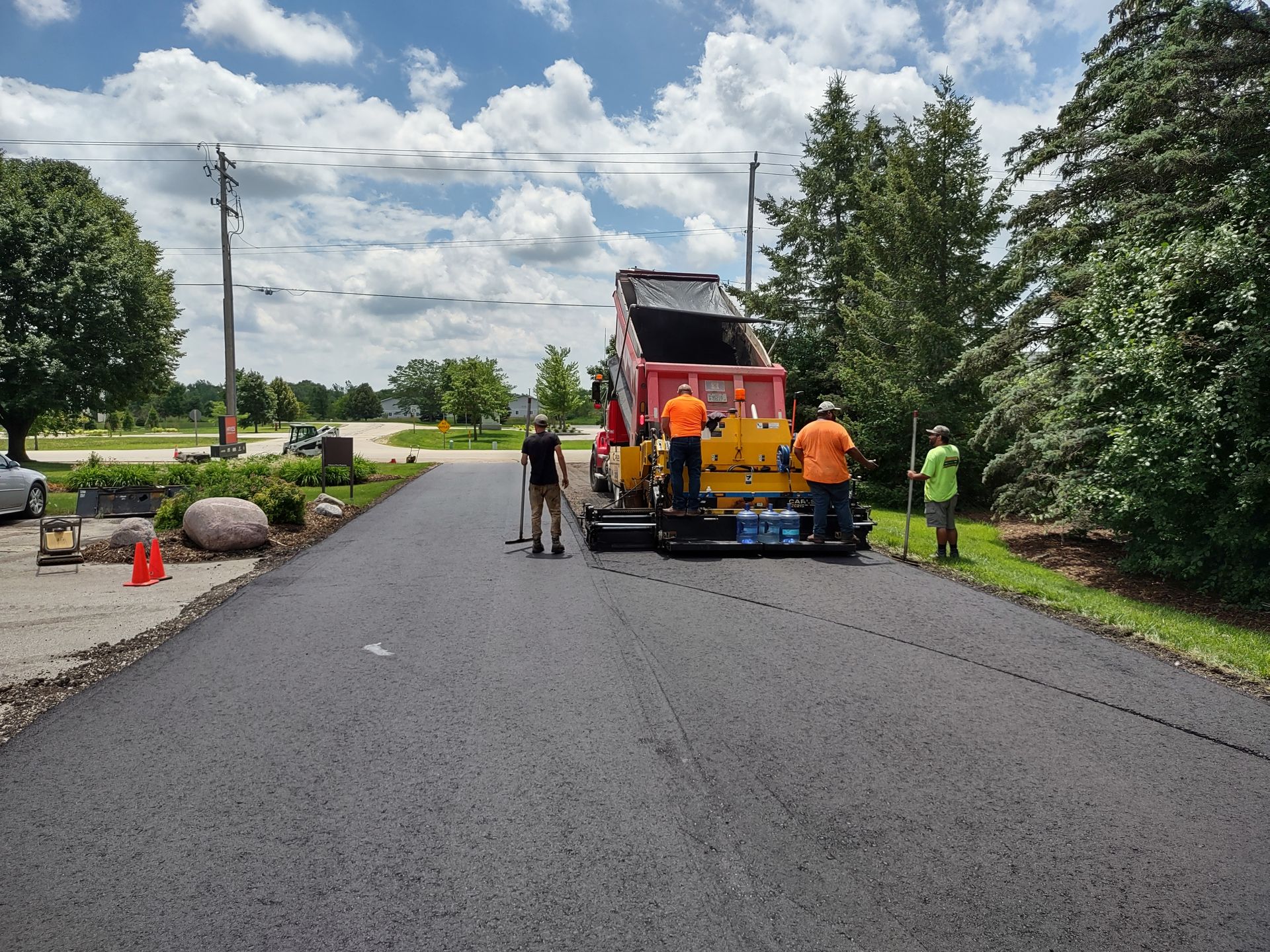 A group of people is standing on the side of a road next to a truck.