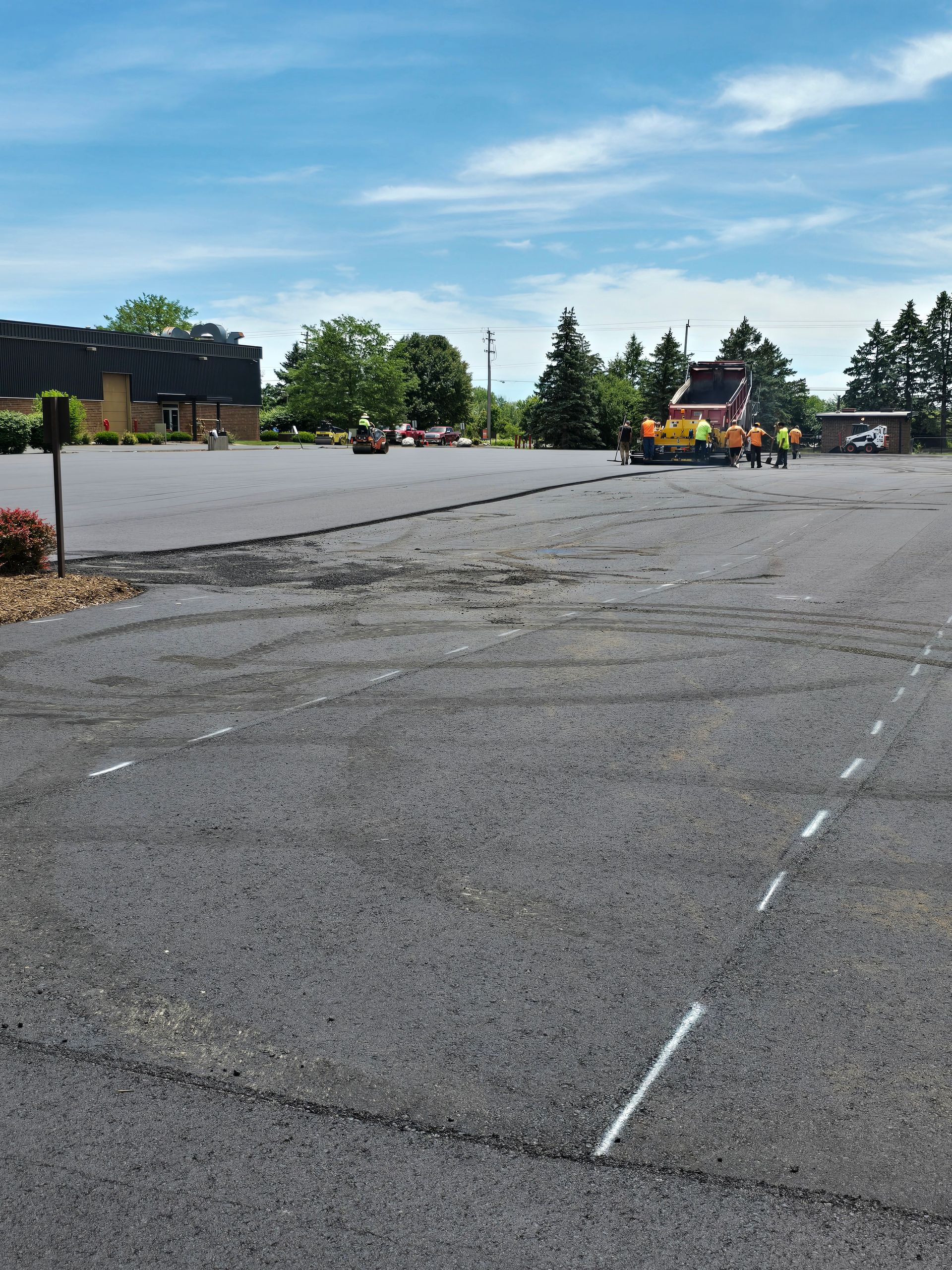 An empty parking lot with a building in the background.