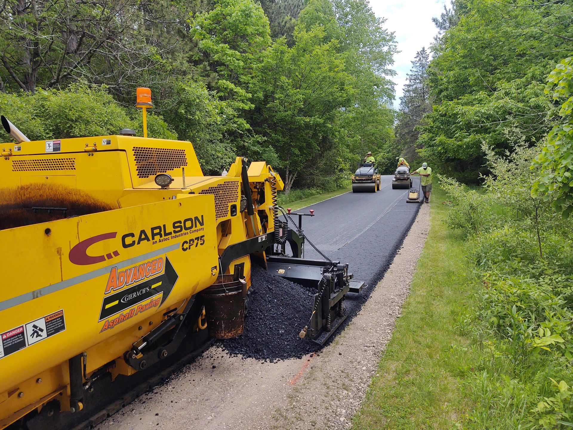 A Carlson asphalt paving machine is working on a road.