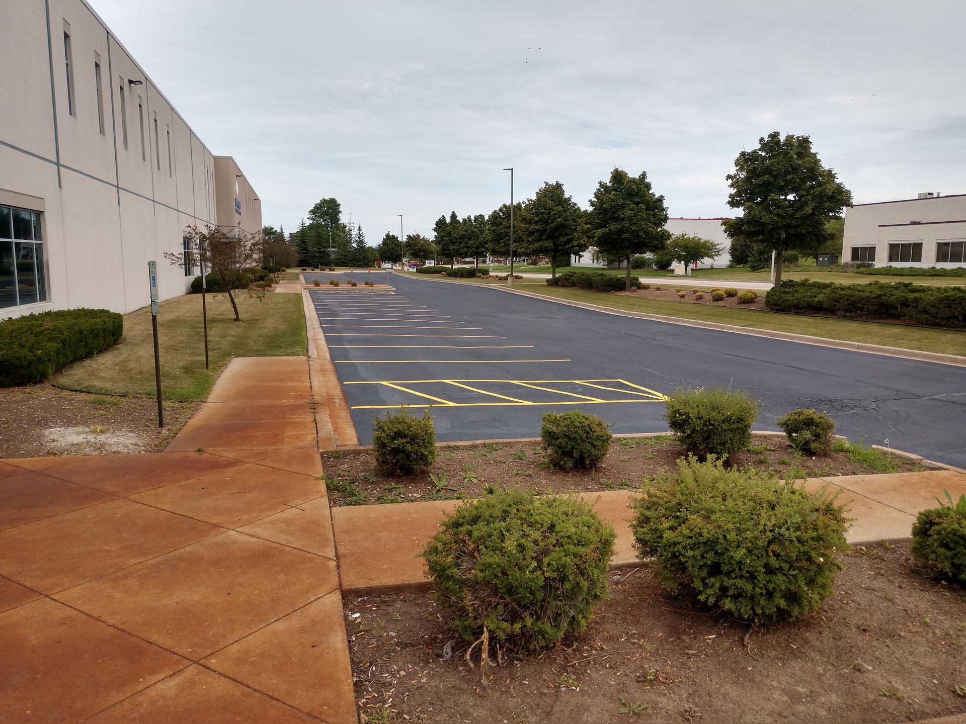 An empty parking lot in front of a large building.