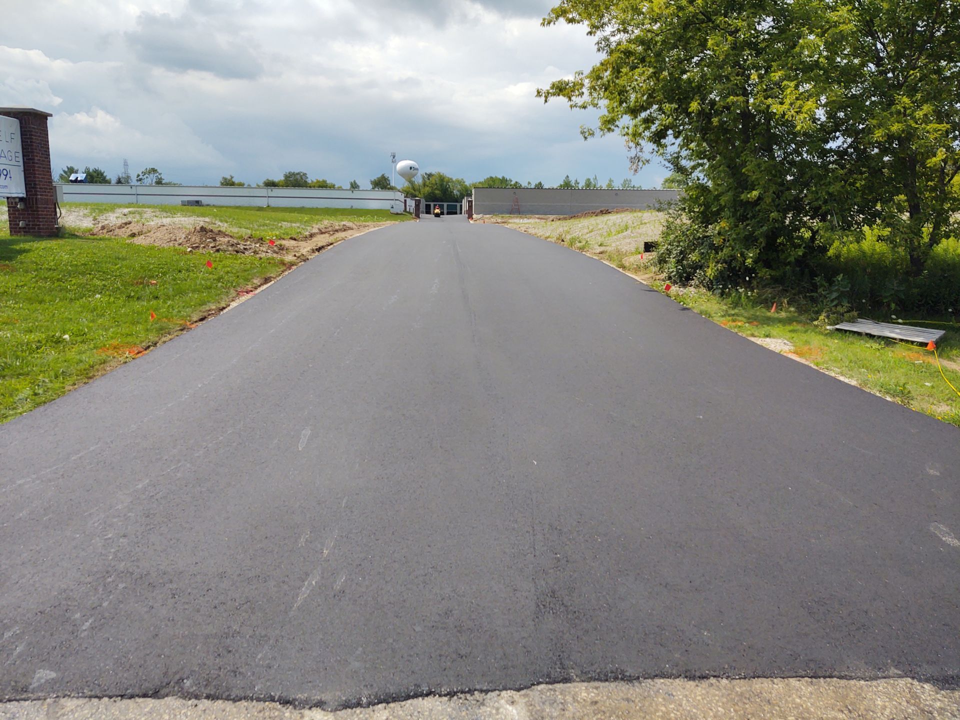 A newly paved road with trees on the side of it.