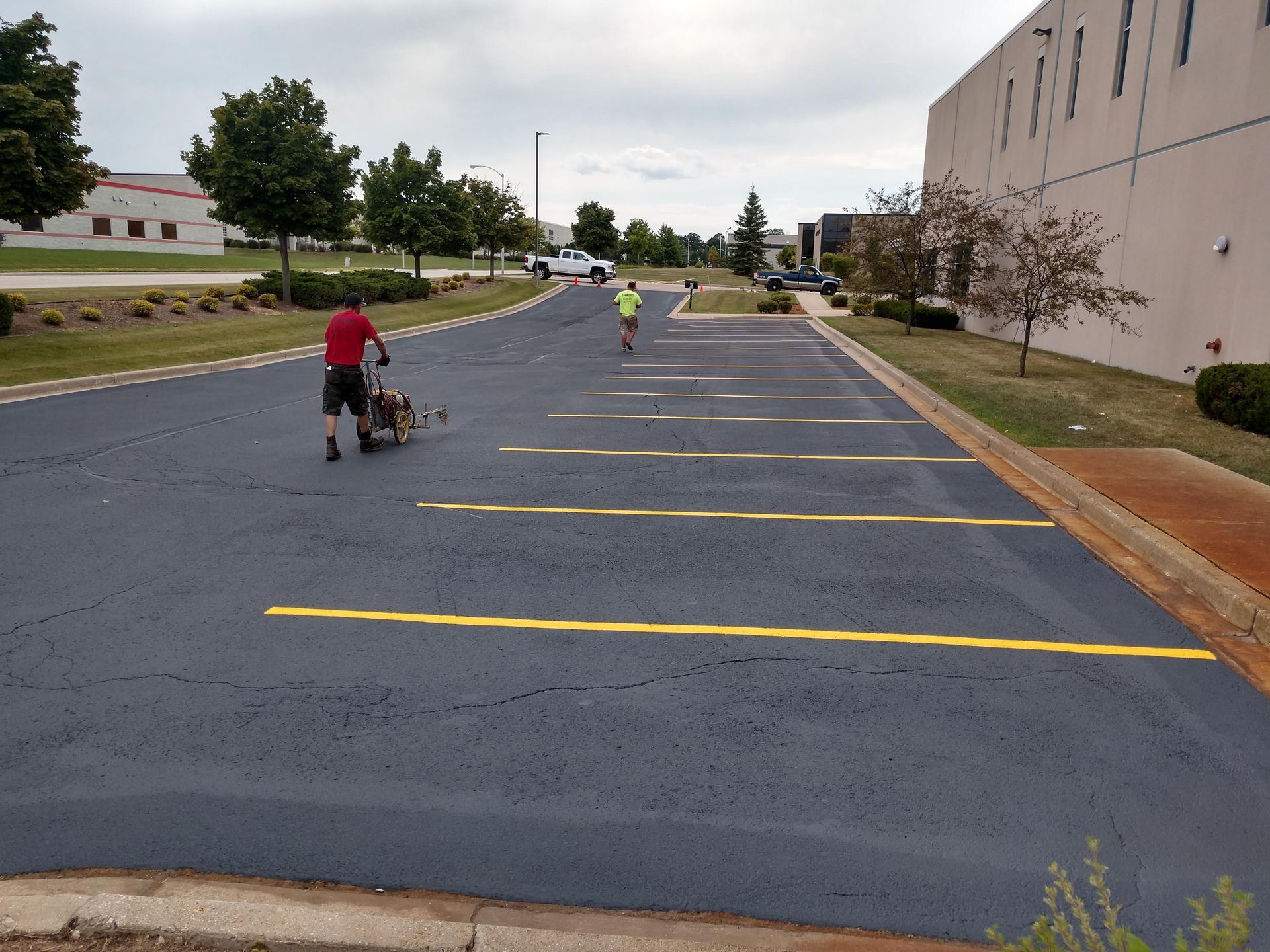 A man walking a dog in a parking lot.