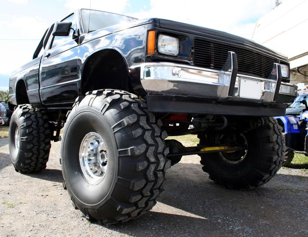 Black lifted pickup truck with oversized off-road tires parked outdoors