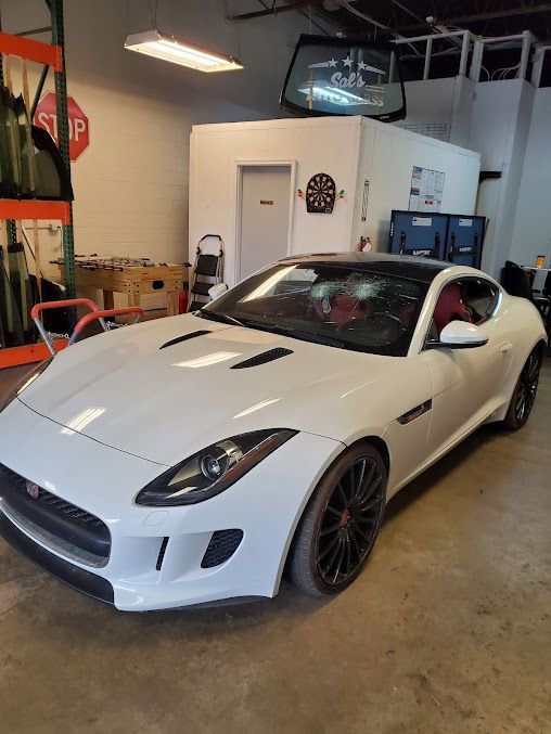 A white jaguar f type is parked in a garage.
