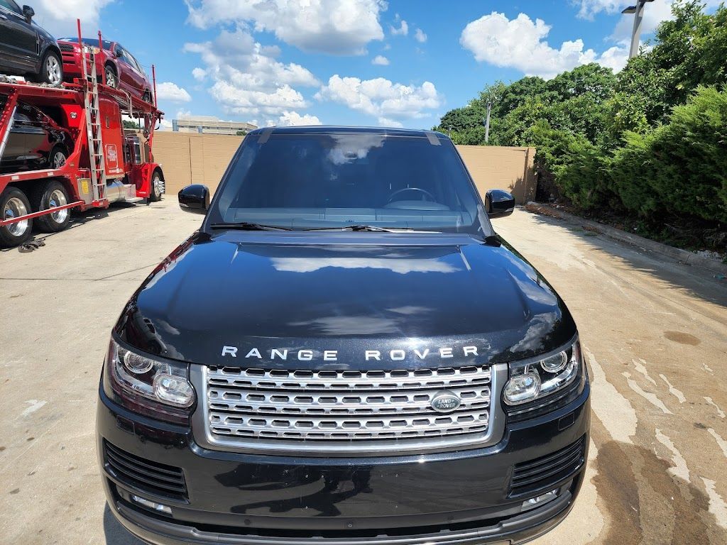 A black range rover is parked in a parking lot.