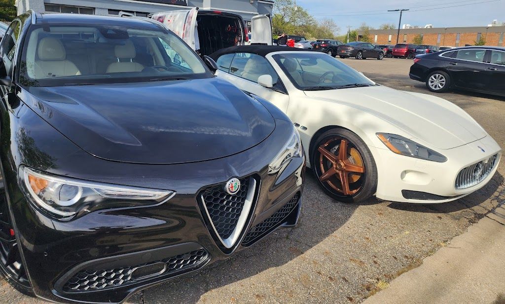 A black car and a white car are parked next to each other in a parking lot.