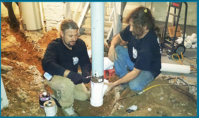 Plumbers fixing pipeline in basement