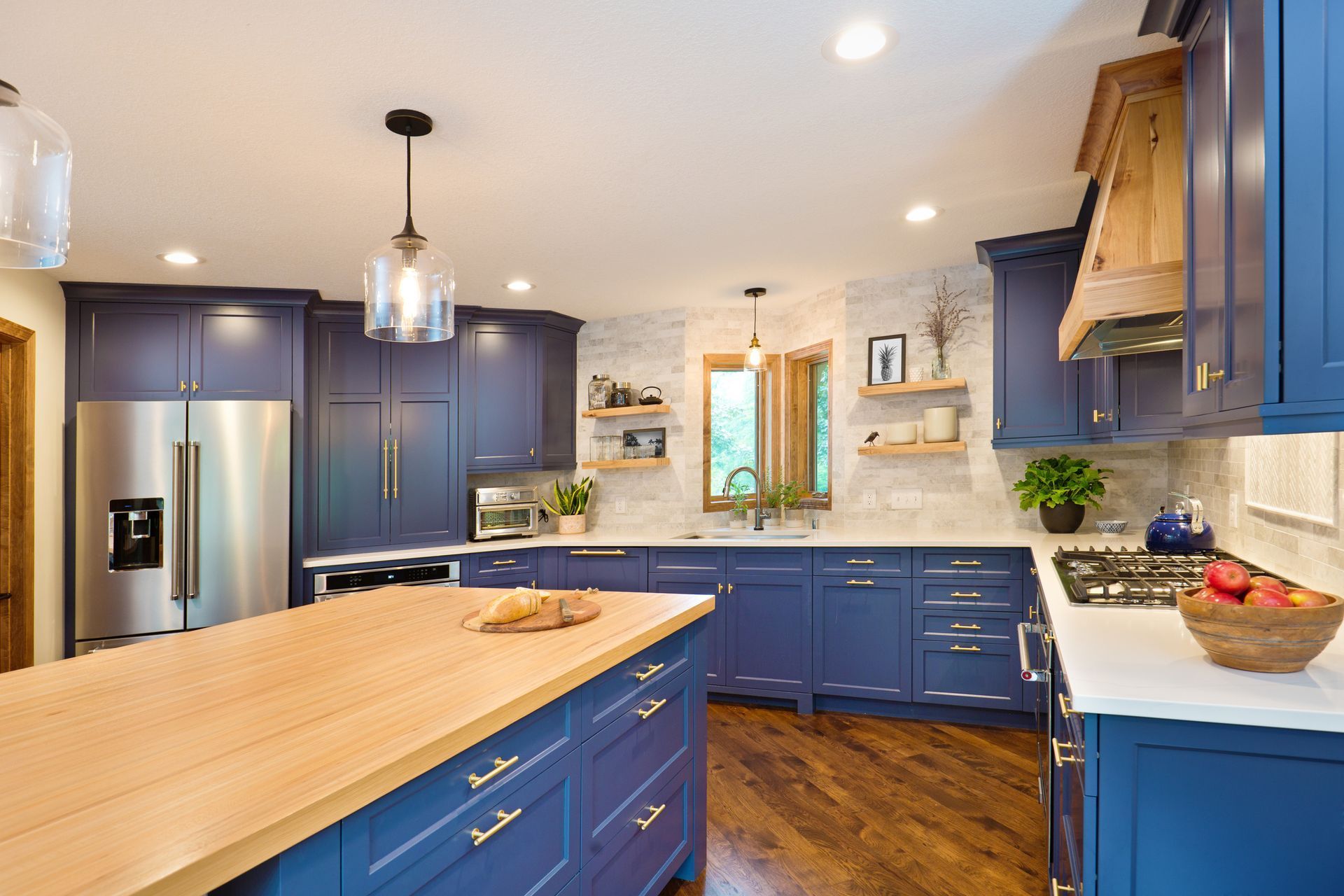 Blue kitchen with wood island and accents.
