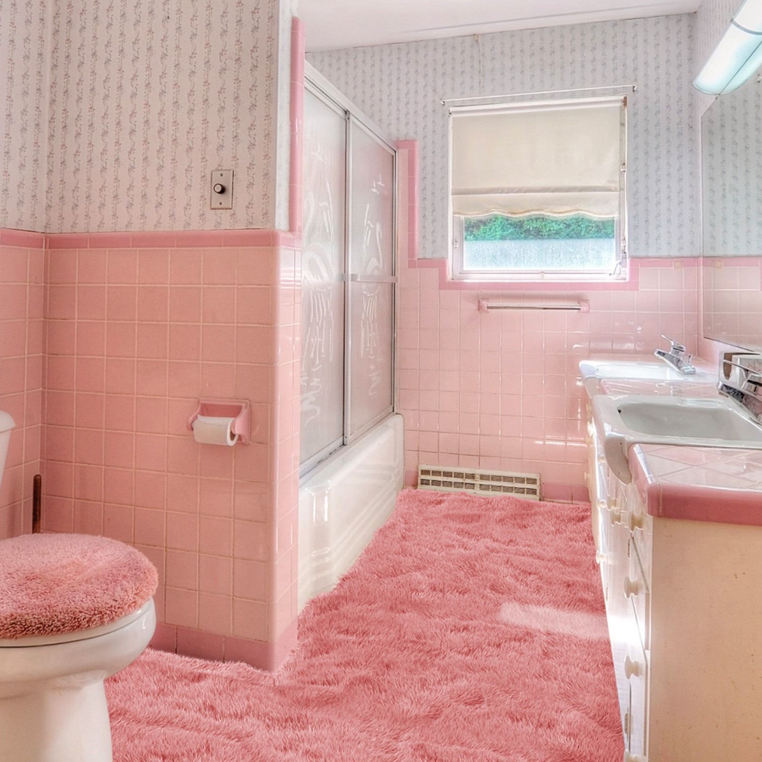 Pink tiled bathroom with a matching fluffy rug and wallpaper.