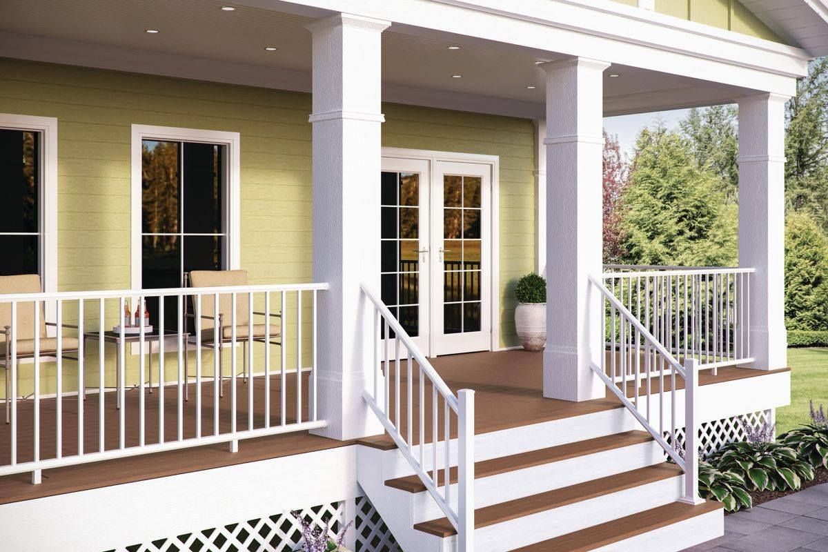 Front porch with white columns, railings, and steps. Brown deck and green siding.