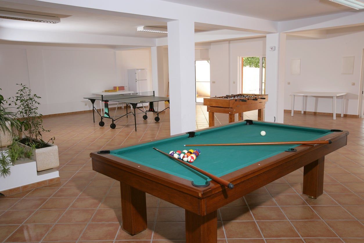 Pool room with pool table, foosball table, and ping pong table.