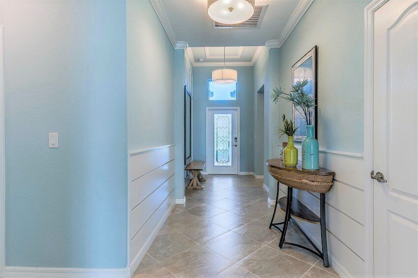Long hallway with light blue walls, white trim, and a decorative table.