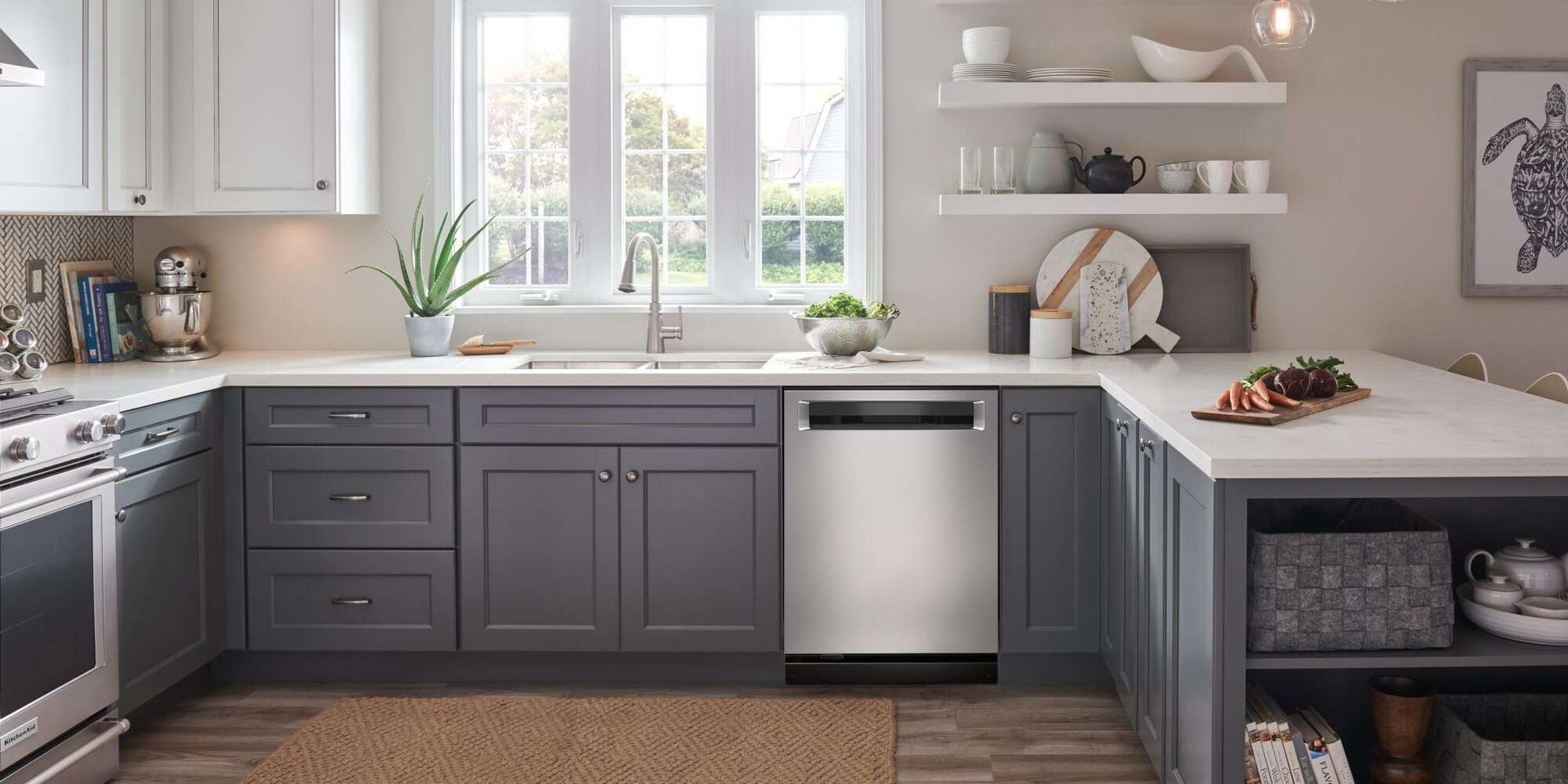 Modern kitchen with gray cabinets, white countertops, stainless steel dishwasher, and window.