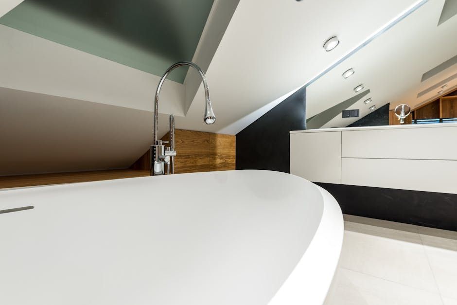 White bathtub in a modern bathroom with sloped ceiling, wood paneling, and a silver faucet.