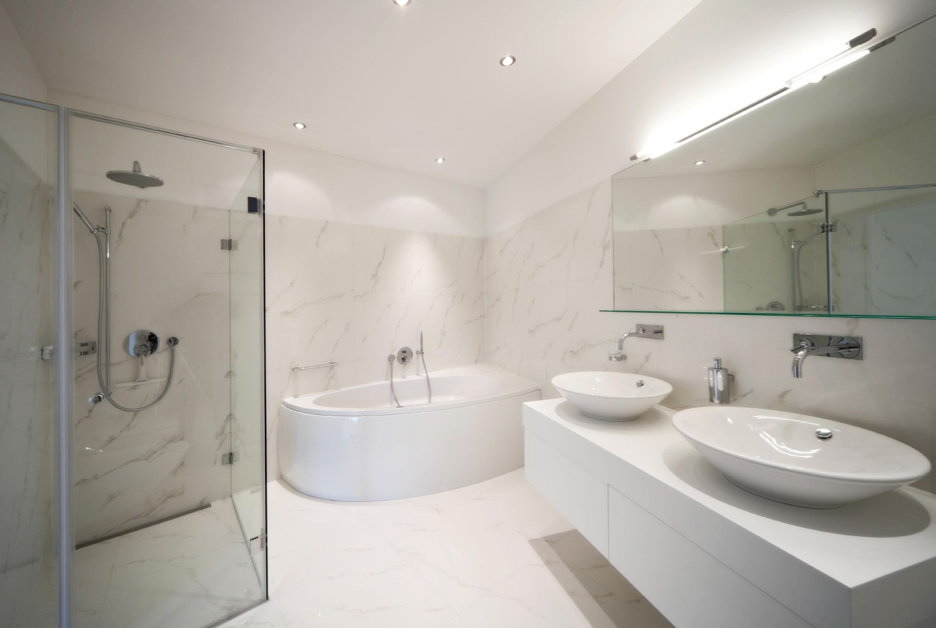 Modern white bathroom with shower, tub, and double sinks. Marble walls and glass shower door.