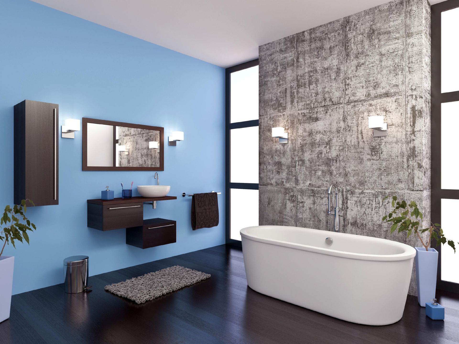 Modern bathroom with blue walls, concrete accent wall, white tub, dark vanity, and large windows.