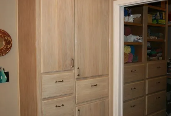 Light wood cabinets with drawers and a doorway to a closet with shelves.