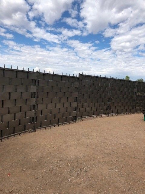 a large basket weave fence wall with a blue sky in the background