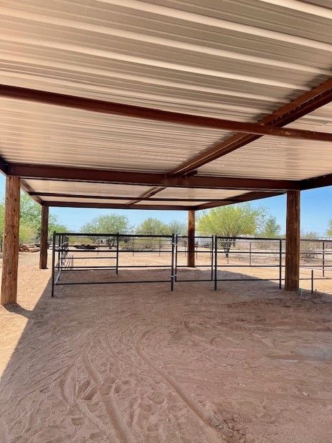a covered area with a metal roof and wooden posts