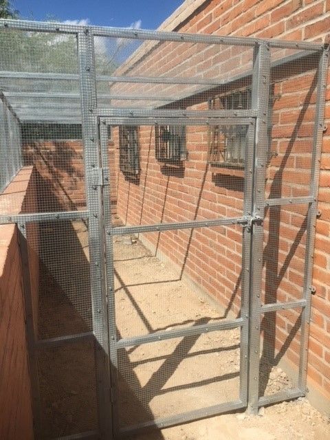 A brick building with a metal fence in front of it.