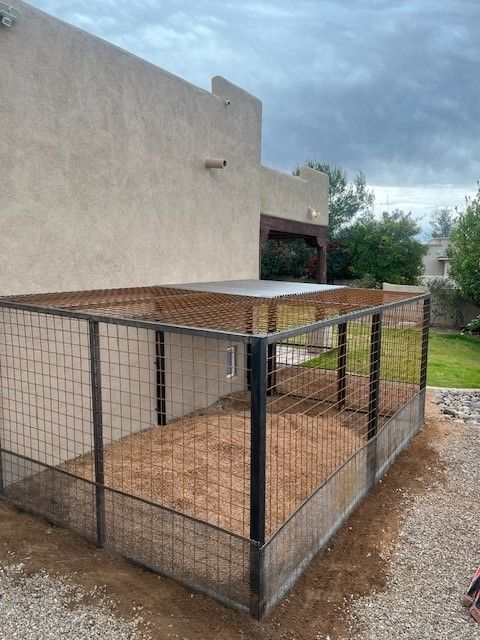 A dog kennel is sitting in front of a house.