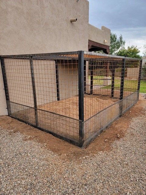 A dog kennel with a fence around it in front of a building